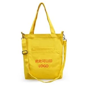 Detail of yellow canvas tote bag with adjustable shoulder strap and front pocket