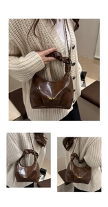 Detail view of brown dumpling bag with ruched cloud handle and gold chain strap
