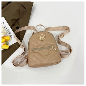 Detailed close-up of khaki quilted leather backpack with metal M logo and strap detail