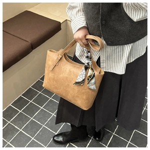 Vue détaillée du sac cabas avec poignée en foulard de soie sur texture cuir