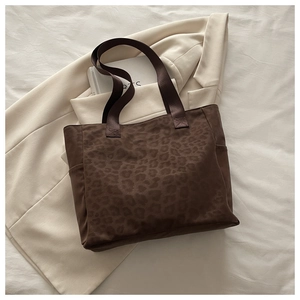 Detail of leopard jacquard tote bag with side pocket and reinforced brown handles