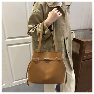 Borsa tote in pelle marrone con chiusura a rotazione in metallo indossata da modella
