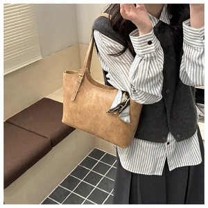 Gros plan du sac fourre-tout marron avec foulard en soie et boucle métallique réglable