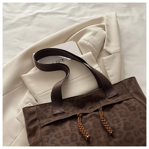 Detail view of dark coffee leopard print tote bag with woven strap and drawstring decoration