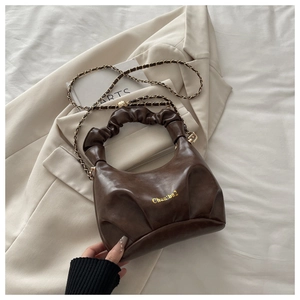 Detail of dark coffee leather handbag with pleated design and gold chain strap