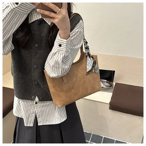 Brown tote bag with polka dot scarf detail shown on shoulder for daily commute style
