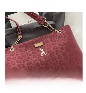 Dettaglio borsa bordeaux leopardata con catena dorata e ciondolo a forma di cervo