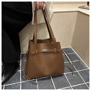 Dettaglio della borsa a secchiello marrone vintage con chiusura dorata e coulisse
