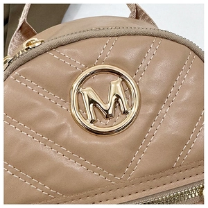 Detailed view of beige V-quilted faux leather with a round golden metal M logo