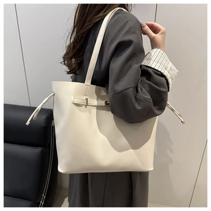 Dettaglio della borsa tote crema con coulisse laterali e fibbia in metallo dorato