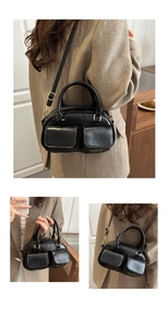 Detail of black faux leather handbag featuring two front flap pockets and fashion lettering
