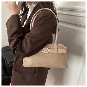 Détail du sac bandoulière en daim beige avec bordure en cuir et boucle dorée sur modèle