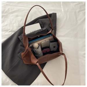 Detailed interior of a brown leather tote bag showing large capacity for daily essentials