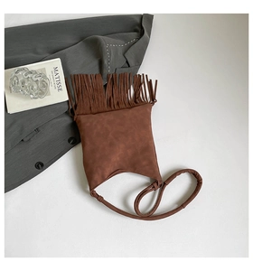 Vue de dessus d'un sac à bandoulière marron à franges en cuir mat et bandoulière fine