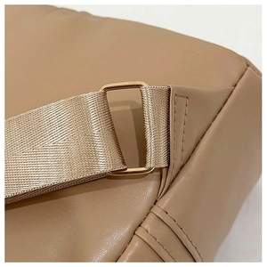 Detail of premium beige faux leather bag showing stitching and light gold metal buckle