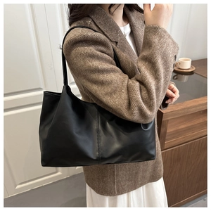 Lifestyle shot of large black matte tote bag with vertical stitching on shoulder