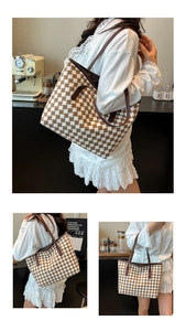 Detail of checkered woven tote bag showing brown leather handles and textured fabric