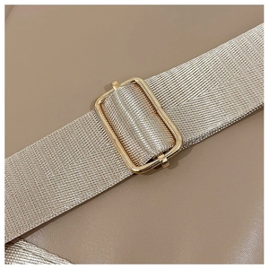 Detail of woven champagne gold shoulder strap with adjustable polished metal buckle