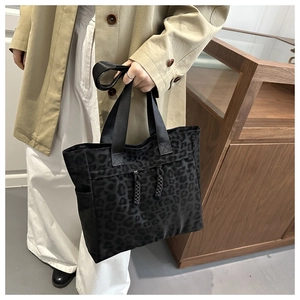 Detail of black leopard print tote bag with woven drawstrings and wide shoulder straps