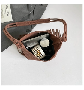 Overhead view showing large storage capacity and suede fringe detail of brown handbag