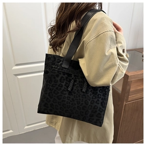 Detail of a black leopard print tote bag featuring woven rope accents and large capacity