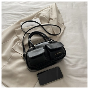 Close-up of black leather bag with double front pockets and gold FASHION lettering