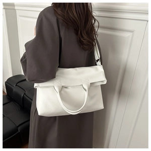 Detail of white large capacity tote with litchi texture on a model shoulder