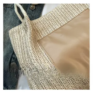 Gros plan d'un sac cabas en paille tressée avec poche en cuir et lettrage de mode embossé