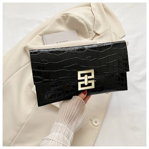 Close-up of black crocodile embossed envelope clutch with a gold geometric metal buckle