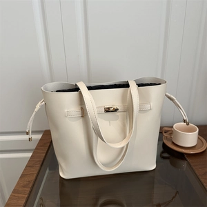 Borsa a secchiello minimalista in pelle beige con chiusura dorata e sacchetto nero