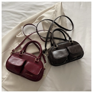 Close-up of retro boston bags with dual flap pockets and golden fashion lettering