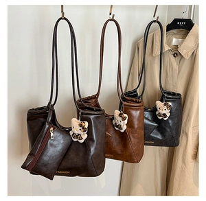 Detailed view of leather tote bags in three colors with matching pouches and charms