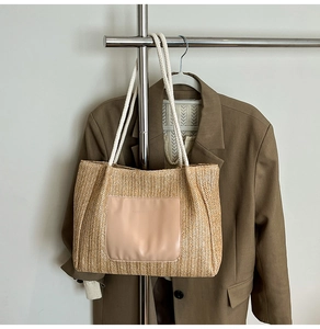 Détail du sac cabas en paille tressée avec poche en cuir rose et anses en corde