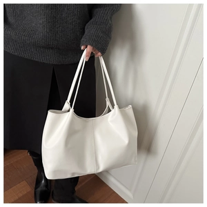 Minimalist white leather tote bag shown on shoulder for daily commute style