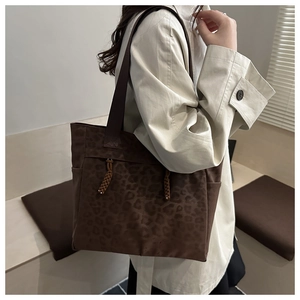 Détail du sac cabas léopard avec corde tressée et poche latérale porté par le modèle