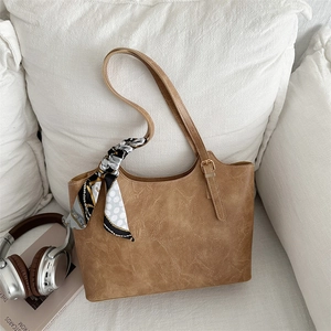 Sac fourre-tout marron classique avec texture vintage et foulard sur fond blanc pur