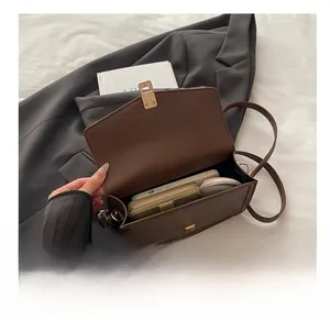 Detail showing the spacious interior of the brown leather square bag with daily items