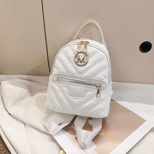 White mini PU leather backpack with V-quilted pattern and gold M logo on beige background