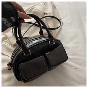 Detail of black bowling bag with dual front pockets and premium gold hardware