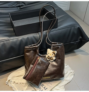 Detail of dark brown faux leather tote bag with small pouch and fashion lettering