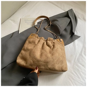 Detail der braunen Wildledertasche mit Rautensteppung und Leder-Kettenriemen