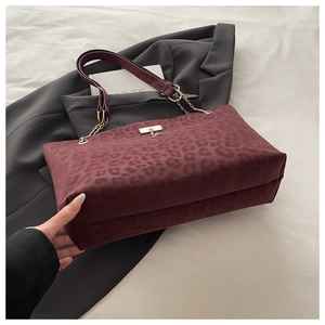 Dettaglio borsa tote leopardata bordeaux con tracolla a catena dorata e fibbia metallo
