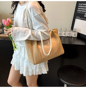 Détail du sac cabas en paille tressée avec anses en coton et poche en tissu rose clair