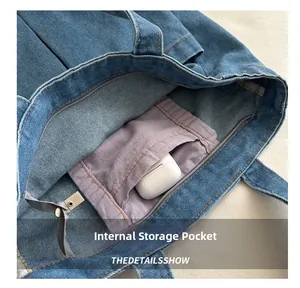Detail of blue denim tote bag interior showing purple storage pocket and spacious compartment