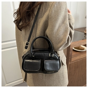 Detail of black leather tote bag with two front pockets and golden FASHION lettering
