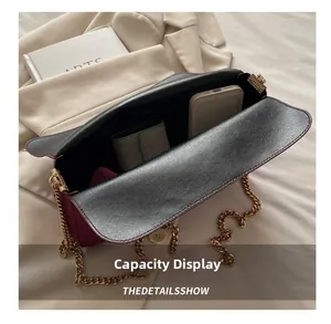 Interior view showing the large capacity of the burgundy leather bag with golden chain