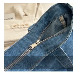 Detailed close-up of the smooth metal zipper and denim texture on the large tote bag