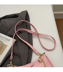 Detailed view of pink lychee textured shoulder bag with golden chain and adjustable strap