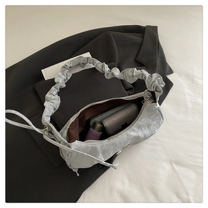 Detail of metallic silver pleated crescent bag interior showing spacious storage capacity