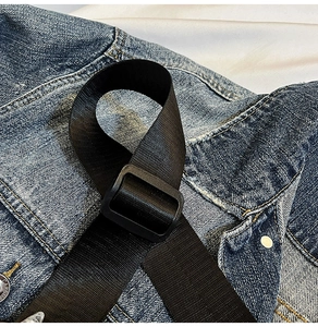 Vista macro del cinturino cargo in nylon con fibbia in plastica su denim blu scuro